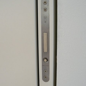 Die Schiebetüre, wenn man den kleinen unteren Knopf drückt, springt der Hebel raus und die Türe kann getätigt werden. Der Spalt ist nur  5,4 cm breit.