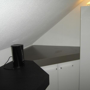 Waschmaschinenplatz, rechts ein Geschirrschrank